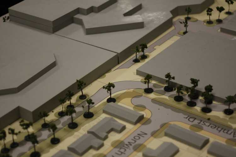 Close-up of a site model with grey residential models in the foreground and a mall in the background