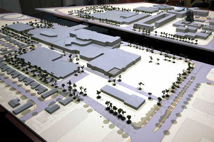 Large grey site model with multiple malls, office buildings and residential homes on two tables